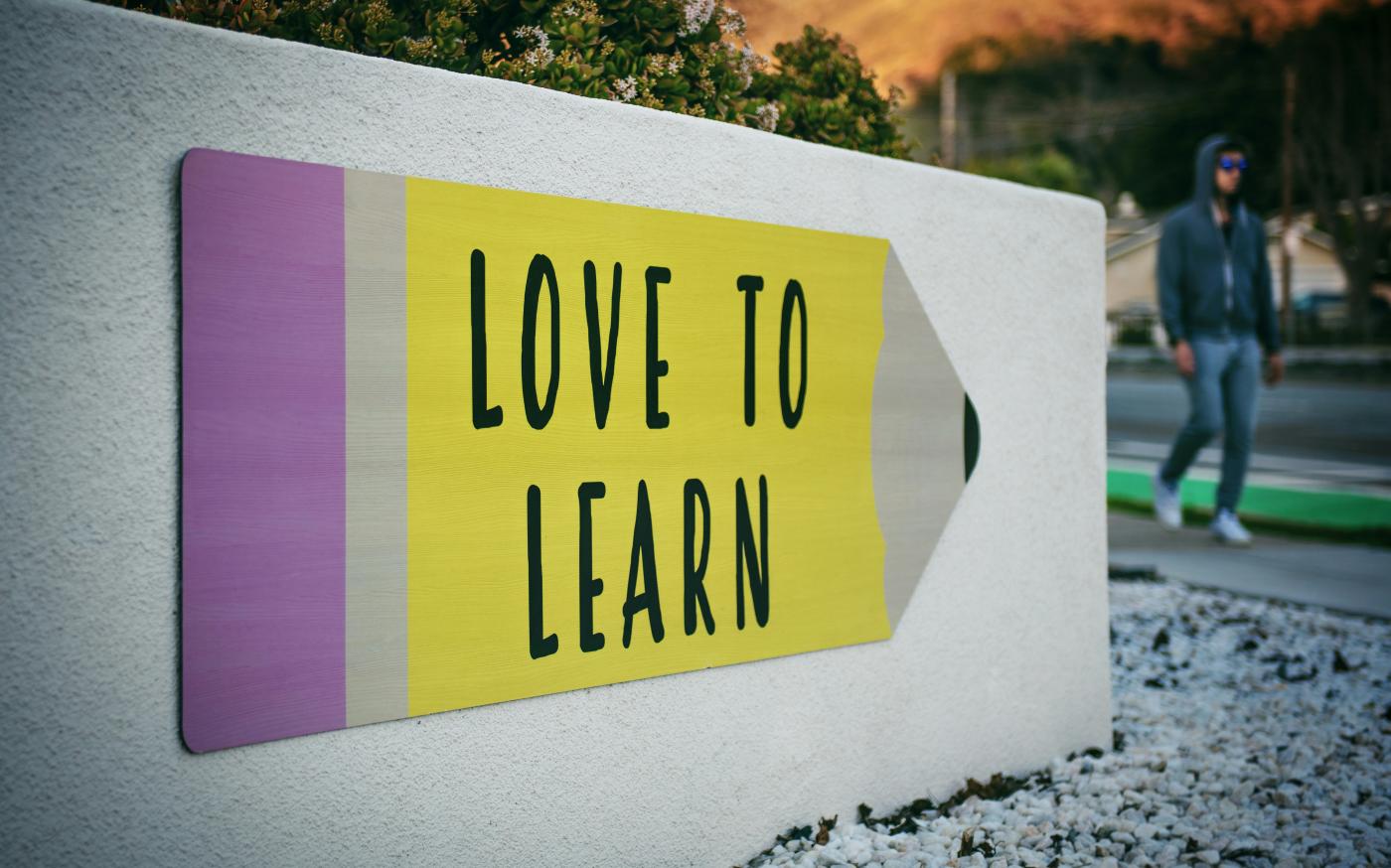love to learn pencil signage on wall near walking man by Tim Mossholder courtesy of Unsplash.